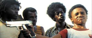 Scene from City of God depicting intense tension as a young boy is held at gunpoint by gang members in Rio's favelas.