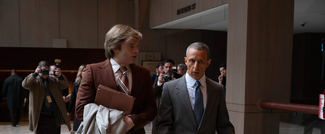 Sebastian Stan as Donald Trump and Jeremy Strong as Roy Cohn in The Apprentice (2024), walking through a courthouse as photographers capture the moment.